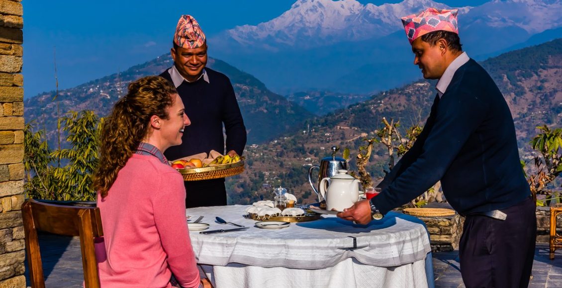 Breakfast served on the patio of the Tiger Mountain Pokhara Lodge with three peaks of the Annapurna Massif (Annapurna South, Annapurna 1 and Hiunchuli) in the background.  Lekhnath, near Pokhara, Nepal.